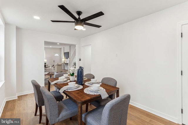 dining space with light wood-style floors, baseboards, and a ceiling fan