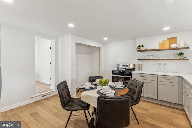 dining area featuring baseboards, light wood-type flooring, visible vents, and recessed lighting