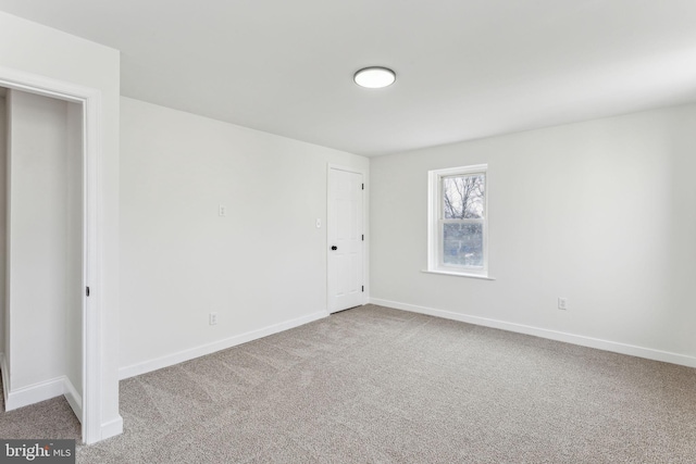 spare room featuring carpet floors and baseboards