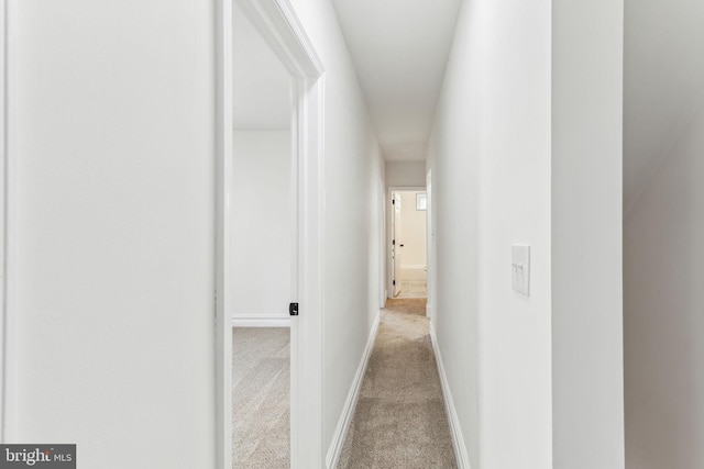 hallway with light carpet and baseboards