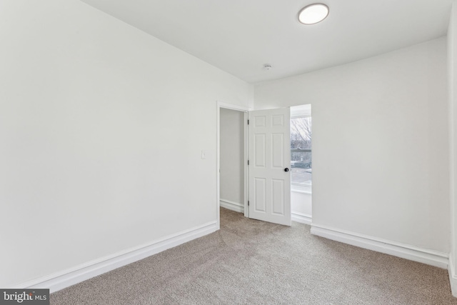 spare room featuring carpet floors and baseboards