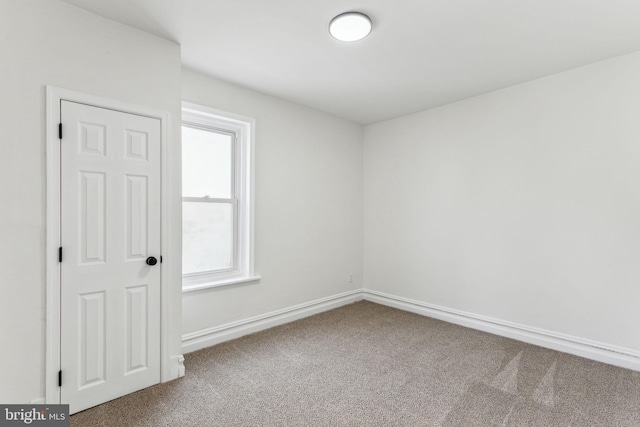 carpeted spare room featuring baseboards