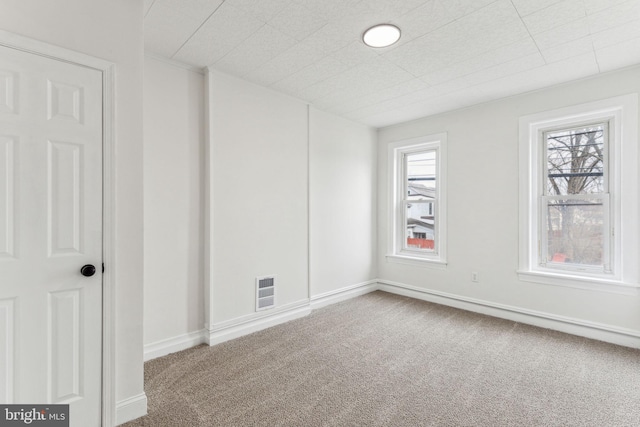 unfurnished room featuring a healthy amount of sunlight, baseboards, and carpet flooring