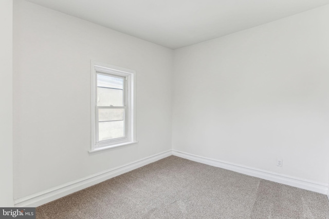 carpeted empty room with baseboards