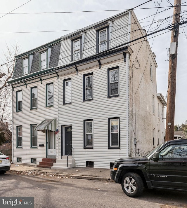 view of front of house featuring entry steps, roof with shingles, and mansard roof