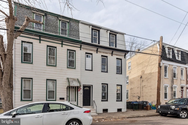 view of property featuring roof with shingles and mansard roof