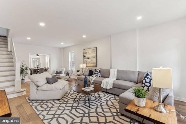 living area with baseboards, stairway, light wood-type flooring, and recessed lighting