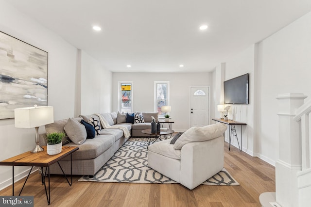 living area featuring baseboards, light wood finished floors, and recessed lighting