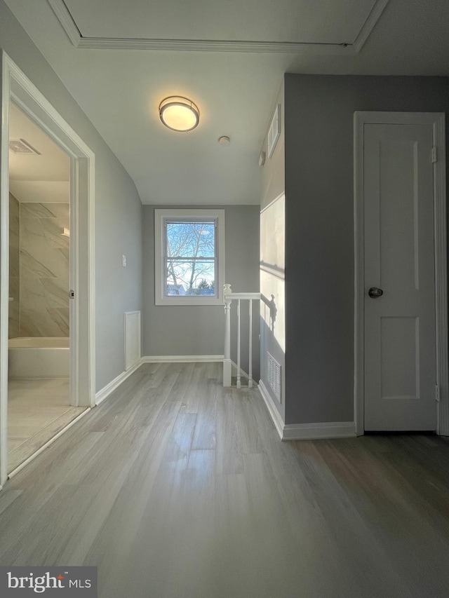 interior space with light wood-type flooring, baseboards, and an upstairs landing