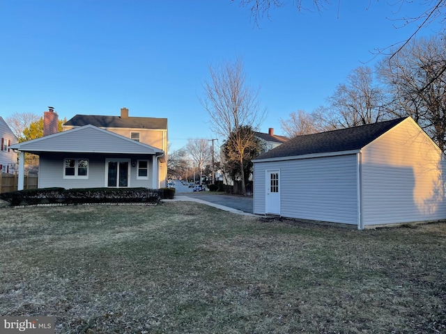 view of side of property featuring a lawn and a chimney