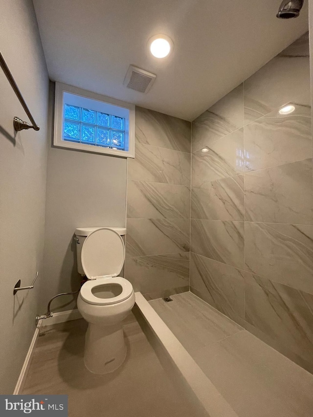 full bathroom featuring a stall shower, baseboards, visible vents, and toilet