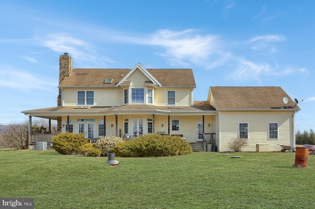 view of front of house with covered porch, a chimney, central AC unit, and a front yard