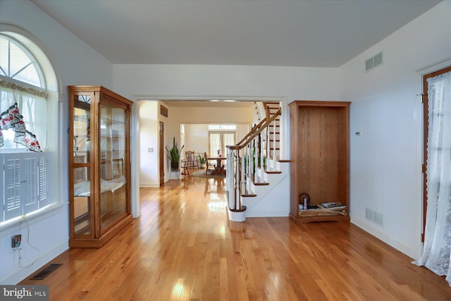 foyer entrance with visible vents, light wood-style flooring, and stairs