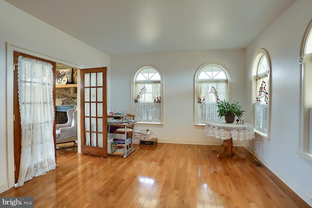 interior space with light wood finished floors, plenty of natural light, visible vents, and baseboards