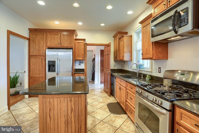 kitchen featuring recessed lighting, stainless steel appliances, a kitchen island, a sink, and brown cabinetry