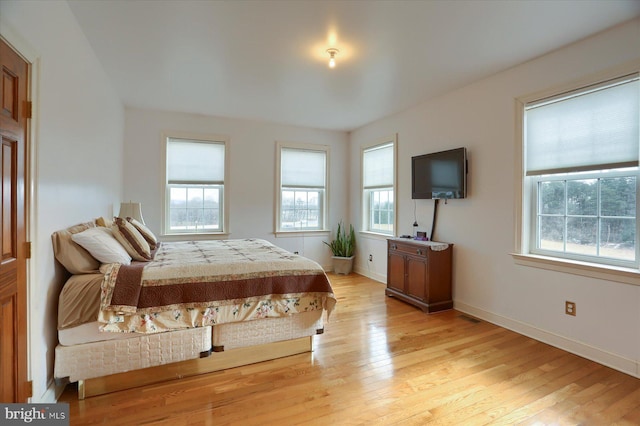 bedroom with light wood-style floors and baseboards