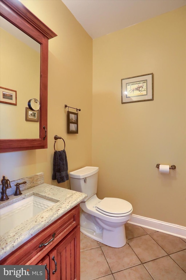 bathroom featuring toilet, tile patterned floors, baseboards, and vanity