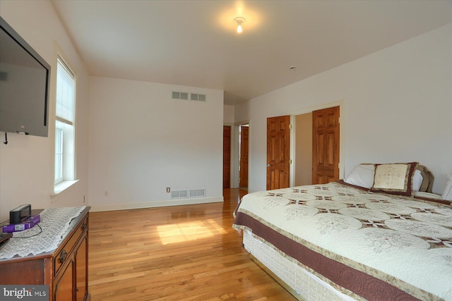 bedroom with light wood-type flooring, baseboards, and visible vents