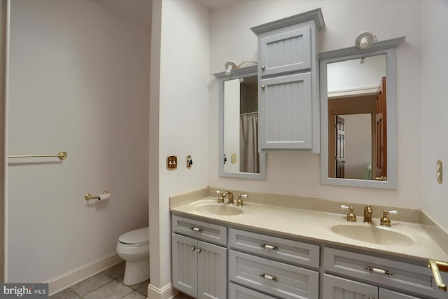 full bath with double vanity, a sink, toilet, and tile patterned floors