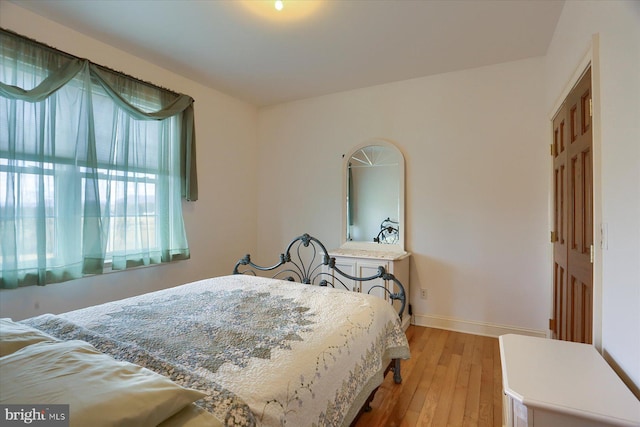 bedroom with baseboards and wood finished floors