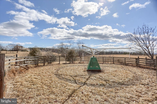 view of community with a rural view and fence