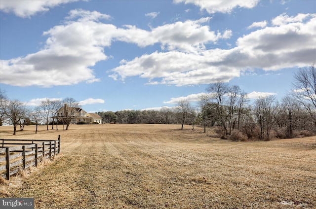 view of yard featuring a rural view and fence