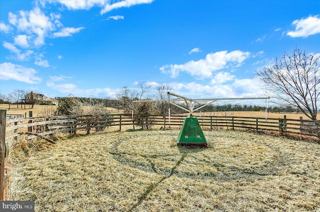 view of home's community with a rural view and fence