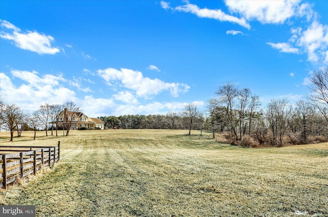 view of yard featuring fence and a rural view