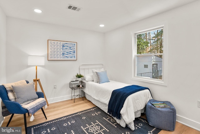 bedroom with recessed lighting, visible vents, baseboards, and wood finished floors