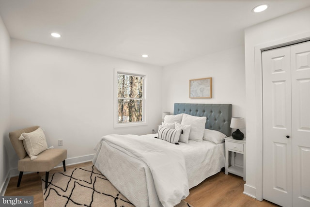 bedroom with baseboards, wood finished floors, and recessed lighting