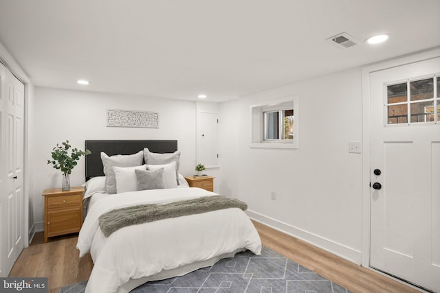 bedroom featuring baseboards, wood finished floors, visible vents, and recessed lighting