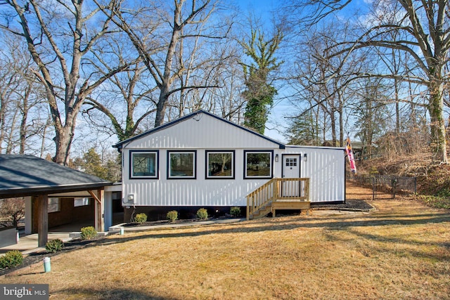 view of front of home featuring driveway, a front lawn, and fence