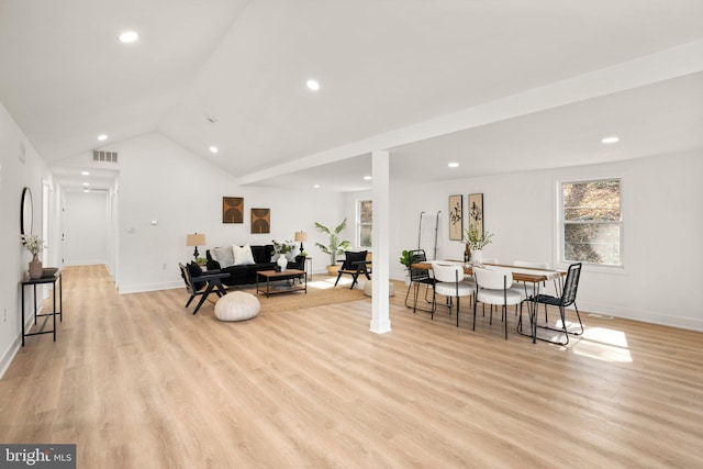 exercise area featuring lofted ceiling, visible vents, and light wood-style floors