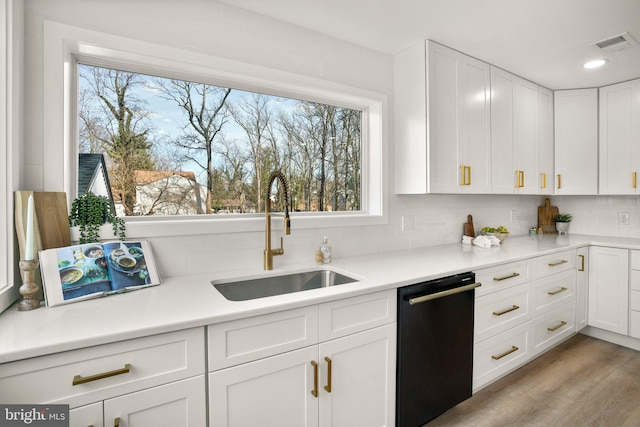 kitchen featuring dishwasher, a sink, visible vents, and white cabinetry