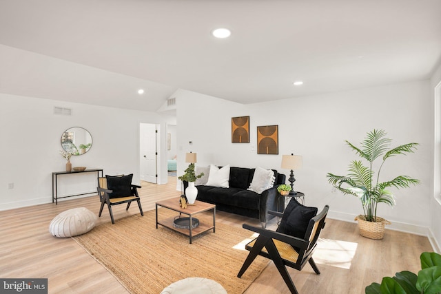 living room featuring baseboards, visible vents, lofted ceiling, light wood-type flooring, and recessed lighting