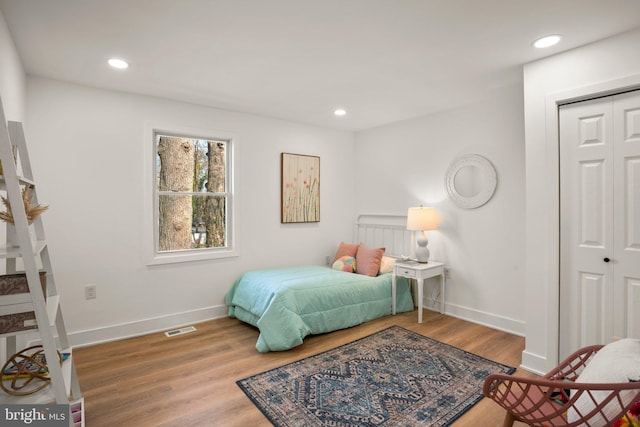 bedroom with recessed lighting, wood finished floors, visible vents, and baseboards