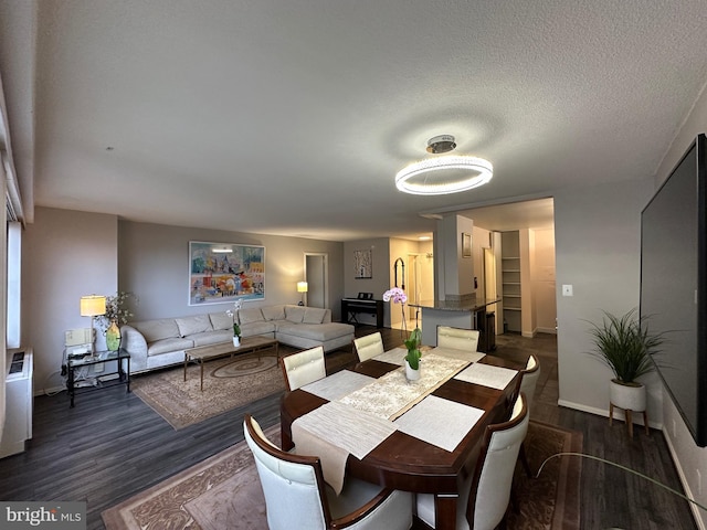 dining area featuring dark wood-style floors, a textured ceiling, and baseboards