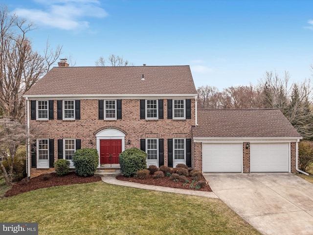 colonial house featuring brick siding, a chimney, concrete driveway, an attached garage, and a front yard