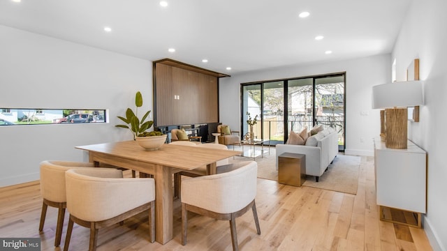 dining space featuring baseboards, light wood finished floors, and recessed lighting