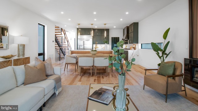 living room with recessed lighting, stairs, and light wood-style flooring