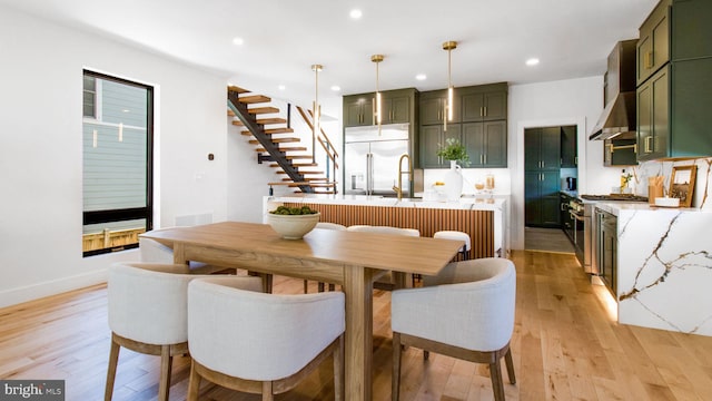 dining space featuring recessed lighting, light wood-style floors, stairway, and baseboards