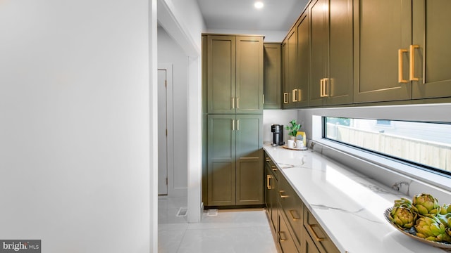 interior space with light stone countertops, green cabinetry, and light tile patterned flooring