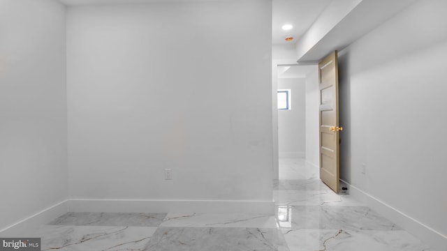 spare room with recessed lighting, marble finish floor, and baseboards