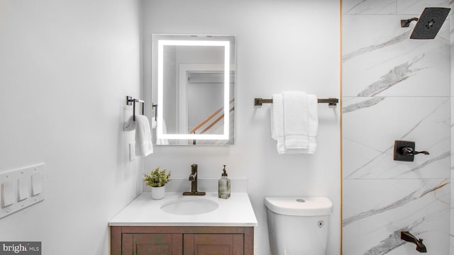full bathroom with vanity, a marble finish shower, and toilet