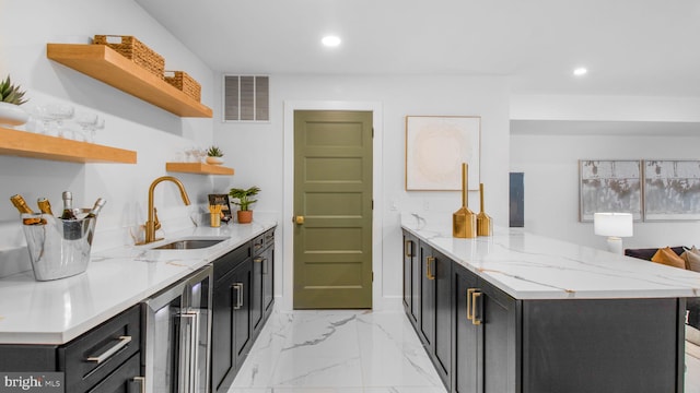 kitchen featuring open shelves, visible vents, a sink, and dark cabinets