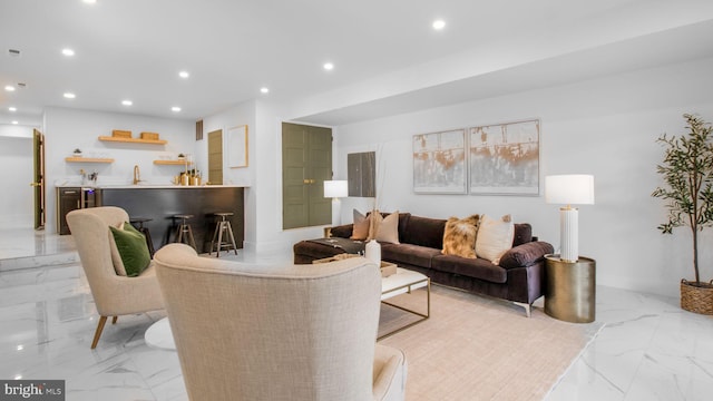 living room featuring marble finish floor, wet bar, baseboards, and recessed lighting
