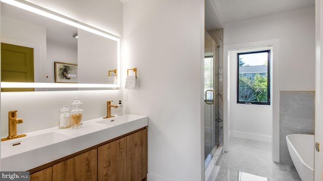 bathroom featuring a shower stall, a freestanding tub, and a sink
