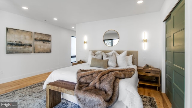 bedroom with baseboards, light wood finished floors, and recessed lighting