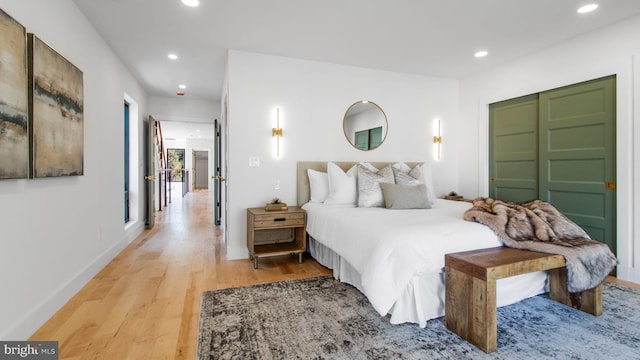bedroom featuring recessed lighting, light wood-type flooring, a closet, and baseboards