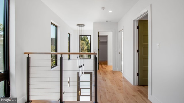 corridor featuring recessed lighting, light wood finished floors, visible vents, an upstairs landing, and baseboards
